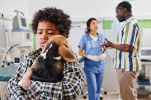Concerned child holding sick puppy at vet clinic showing pet symptoms and possible pet digestive issues during a pet emergency